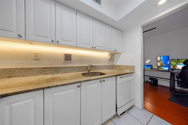 kitchen with white dishwasher, a sink, visible vents, and white cabinets