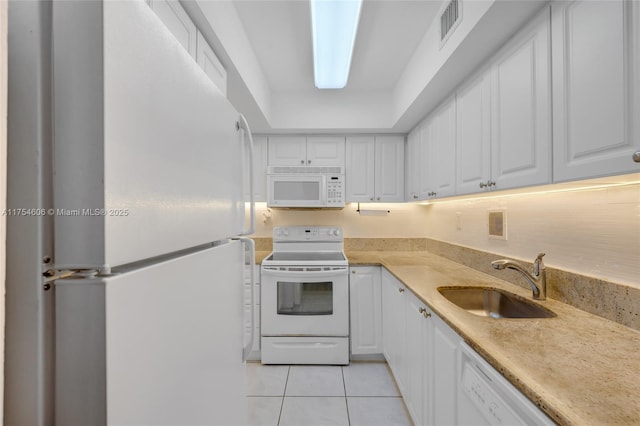 kitchen featuring light tile patterned floors, visible vents, white cabinetry, a sink, and white appliances