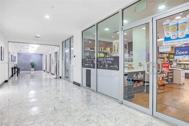 hallway featuring marble finish floor and baseboards