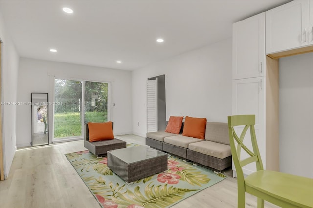 living area with baseboards, recessed lighting, and light wood-style floors