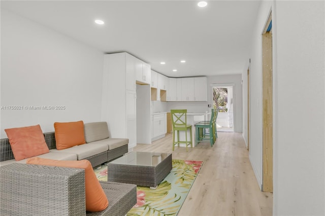 living room with light wood-style flooring and recessed lighting