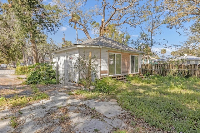 back of property featuring an outbuilding and fence