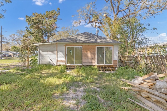 rear view of property with entry steps and fence