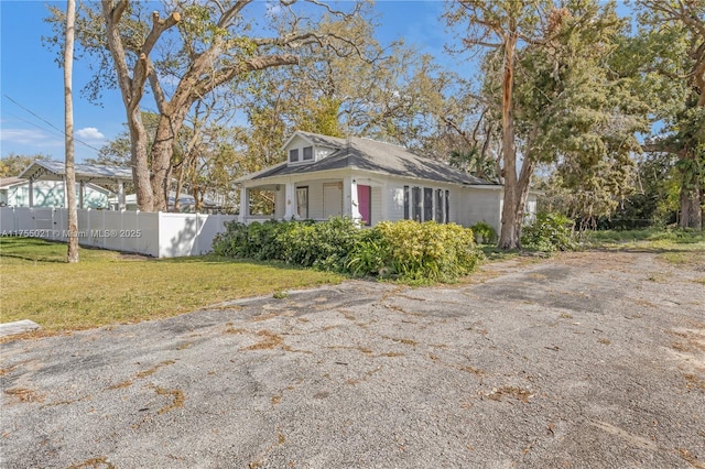 view of property exterior with a lawn and fence