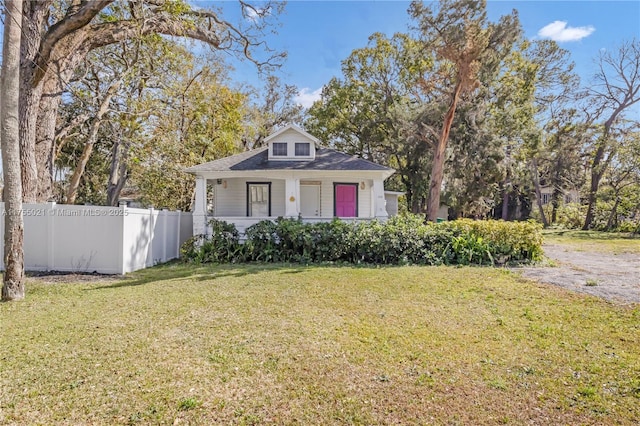 bungalow-style house with covered porch, fence, and a front yard