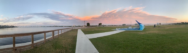 exterior space with a water view and a lawn