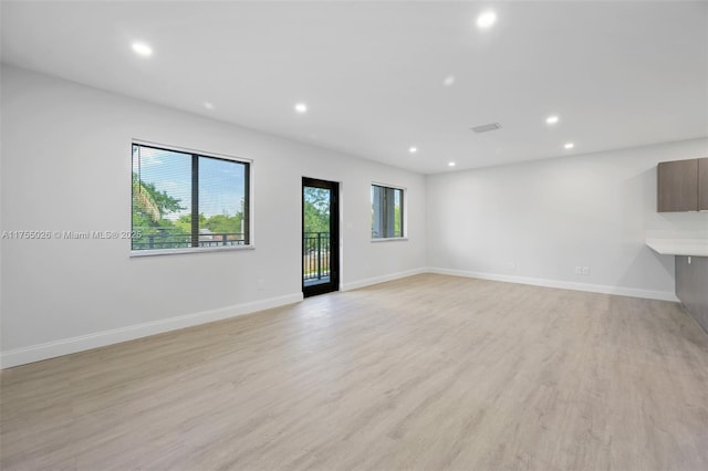 unfurnished living room with light wood-type flooring, visible vents, baseboards, and recessed lighting