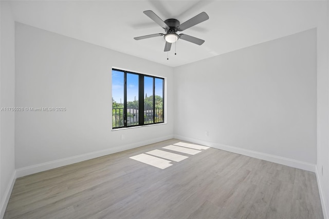 empty room featuring wood finished floors, a ceiling fan, and baseboards