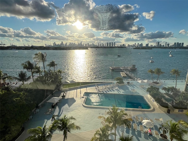 community pool featuring a view of city, a patio area, and a water view