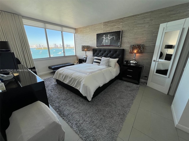 tiled bedroom featuring a view of city and baseboards