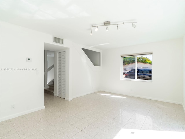 1323 NE 5th Ave, Fort Lauderdale, FL 33304 - empty room featuring stairway, baseboards, and track lighting