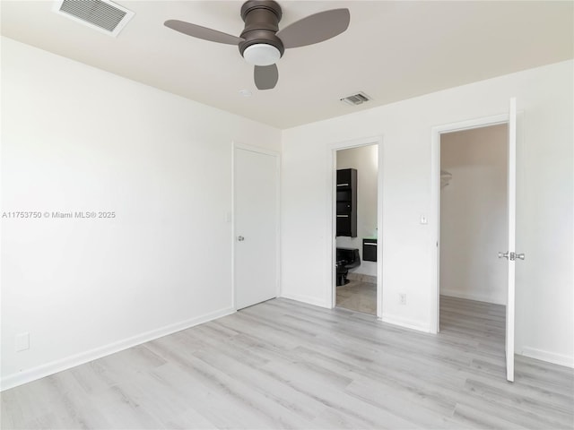 1323 NE 5th Ave, Fort Lauderdale, FL 33304 - unfurnished bedroom featuring a spacious closet, a closet, light wood-type flooring, ensuite bath, and baseboards
