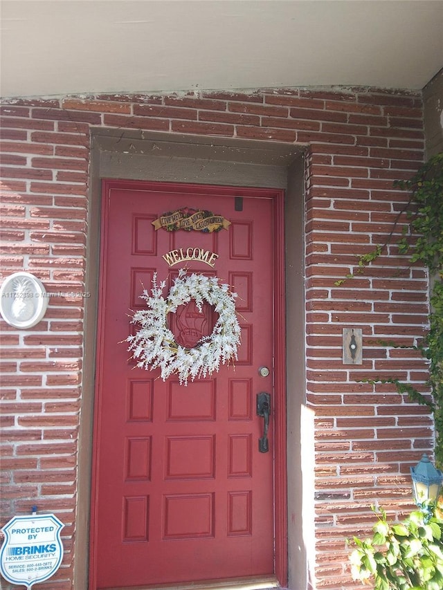 entrance to property featuring brick siding