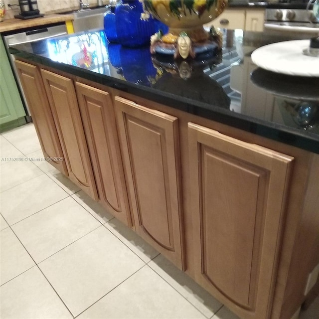 bar featuring stainless steel dishwasher and light tile patterned floors