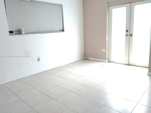 empty room featuring baseboards and french doors