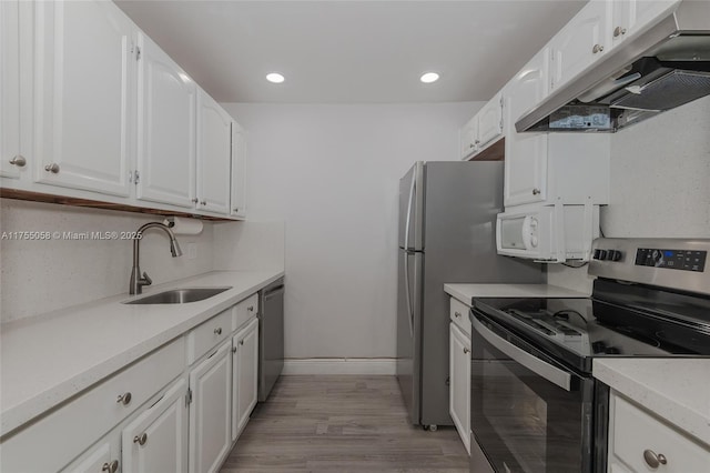 kitchen with white cabinets, under cabinet range hood, stainless steel appliances, and a sink