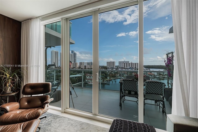 doorway to outside with a view of city, a water view, tile patterned flooring, and floor to ceiling windows