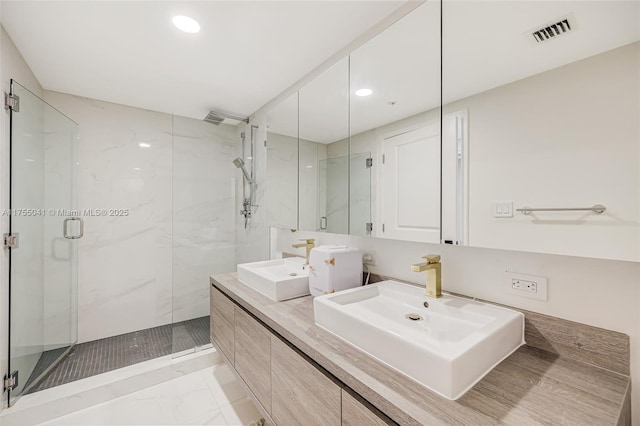 bathroom with marble finish floor, a marble finish shower, visible vents, and a sink