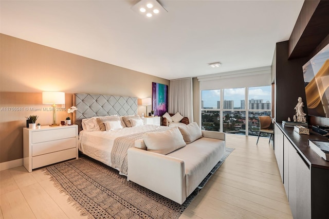 bedroom with light wood-style flooring and baseboards