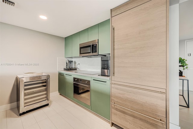 kitchen with beverage cooler, visible vents, appliances with stainless steel finishes, light countertops, and green cabinets