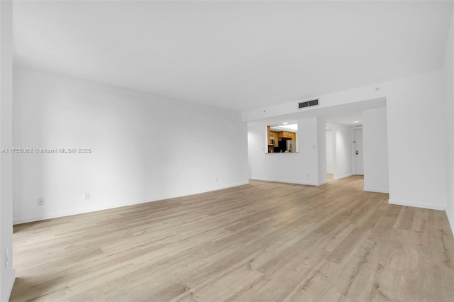 unfurnished living room featuring light wood-type flooring, baseboards, and visible vents