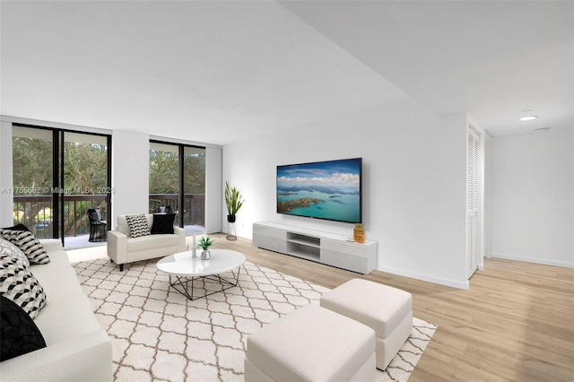 living room with expansive windows, recessed lighting, baseboards, and wood finished floors