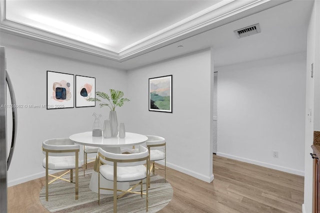 dining area featuring baseboards, visible vents, and light wood finished floors