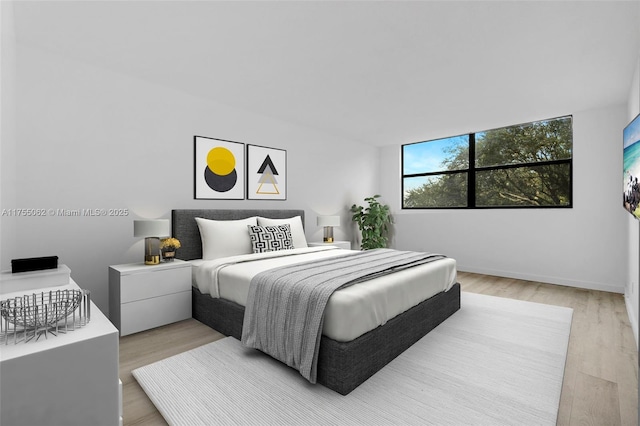 bedroom with light wood-style floors and baseboards