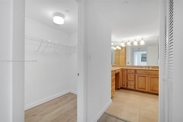 walk in closet with a sink and light tile patterned floors