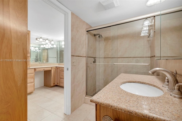 bathroom featuring a stall shower, tile patterned flooring, tile walls, and vanity