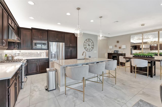 kitchen featuring appliances with stainless steel finishes, ornamental molding, a sink, dark brown cabinets, and backsplash