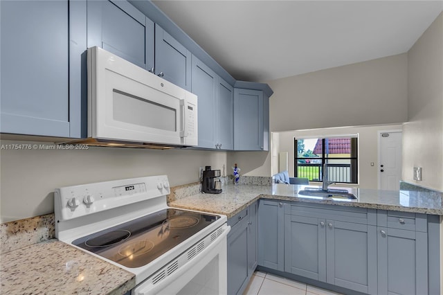 kitchen with light tile patterned floors, white appliances, a sink, and light stone counters