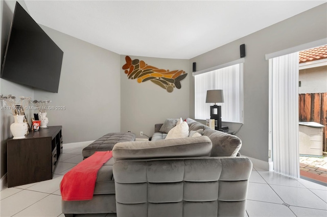 living area featuring light tile patterned floors and baseboards