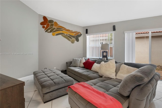 living area featuring baseboards and light tile patterned floors