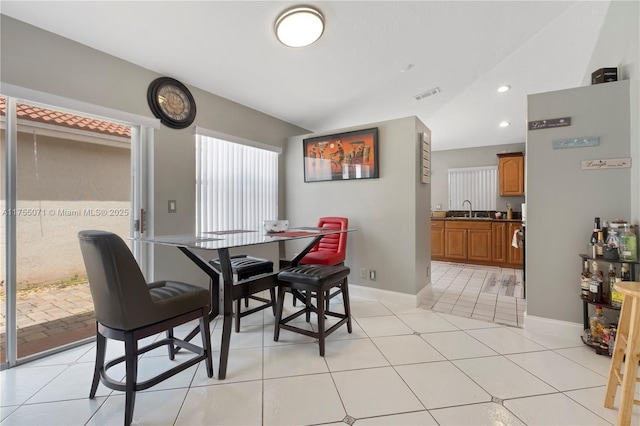 dining area featuring lofted ceiling, visible vents, baseboards, and light tile patterned floors