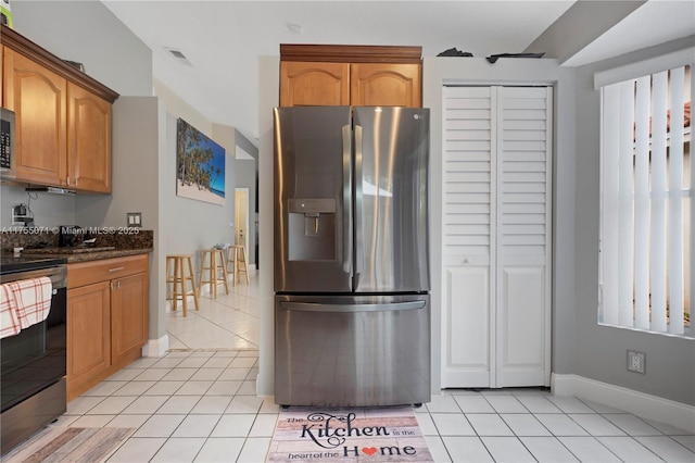 kitchen with appliances with stainless steel finishes, visible vents, baseboards, and light tile patterned flooring