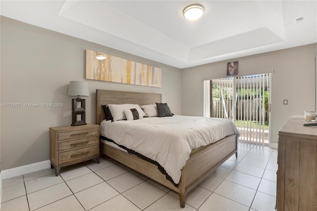 bedroom with access to exterior, a raised ceiling, baseboards, and light tile patterned floors