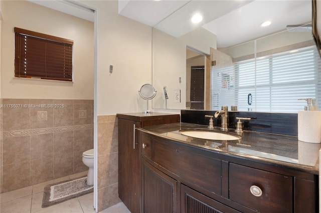 bathroom with tile patterned flooring, toilet, recessed lighting, vanity, and tile walls