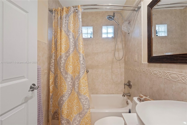 bathroom with shower / tub combo, tile walls, and toilet