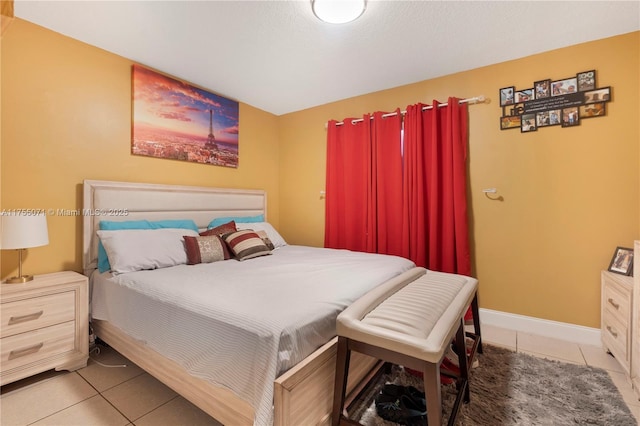 bedroom featuring baseboards and tile patterned floors