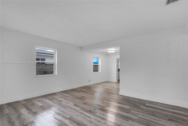 unfurnished room with visible vents, baseboards, and wood finished floors