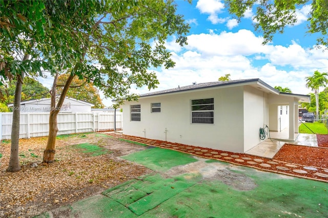 back of house featuring fence, a patio, and stucco siding