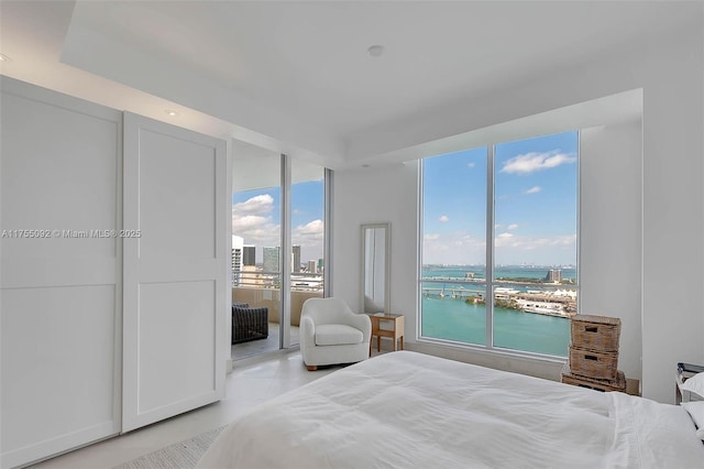 bedroom with a water view and a city view