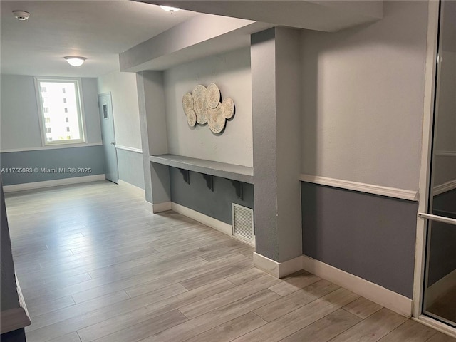 interior space with visible vents, baseboards, and wood finished floors