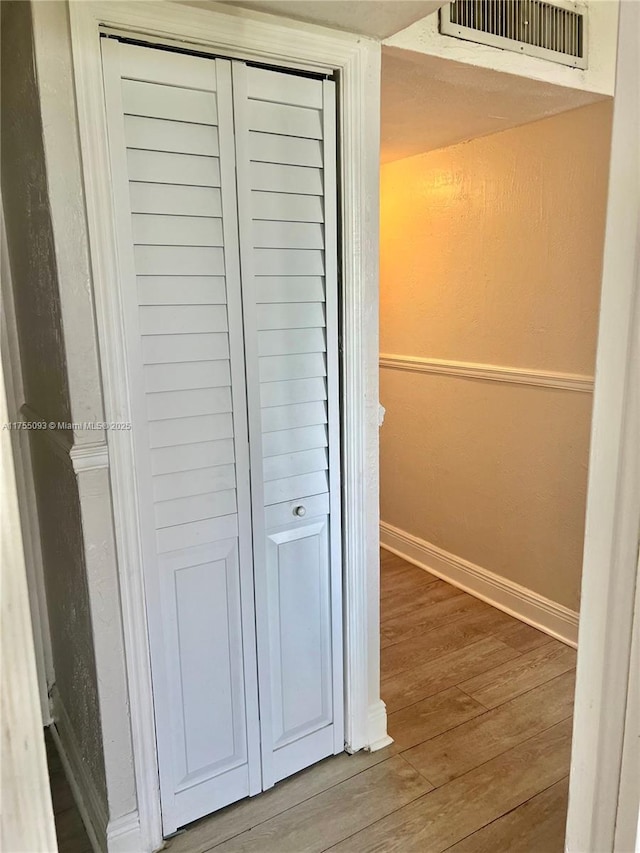 interior details with wood finished floors, visible vents, and baseboards