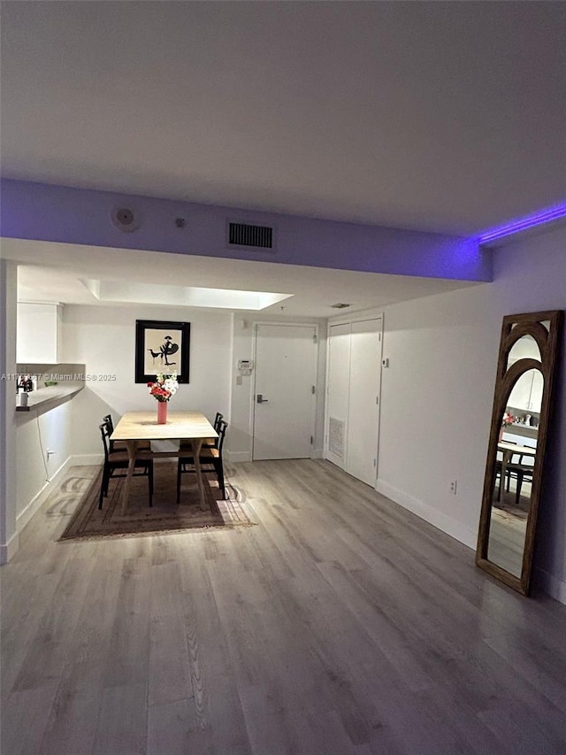 dining space featuring visible vents, baseboards, and wood finished floors