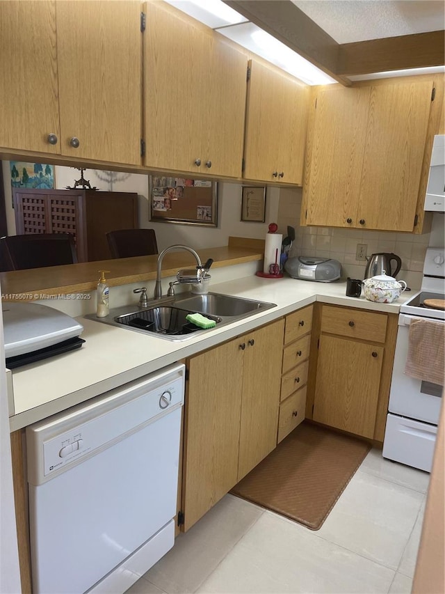 kitchen featuring white appliances, light tile patterned floors, a sink, light countertops, and backsplash