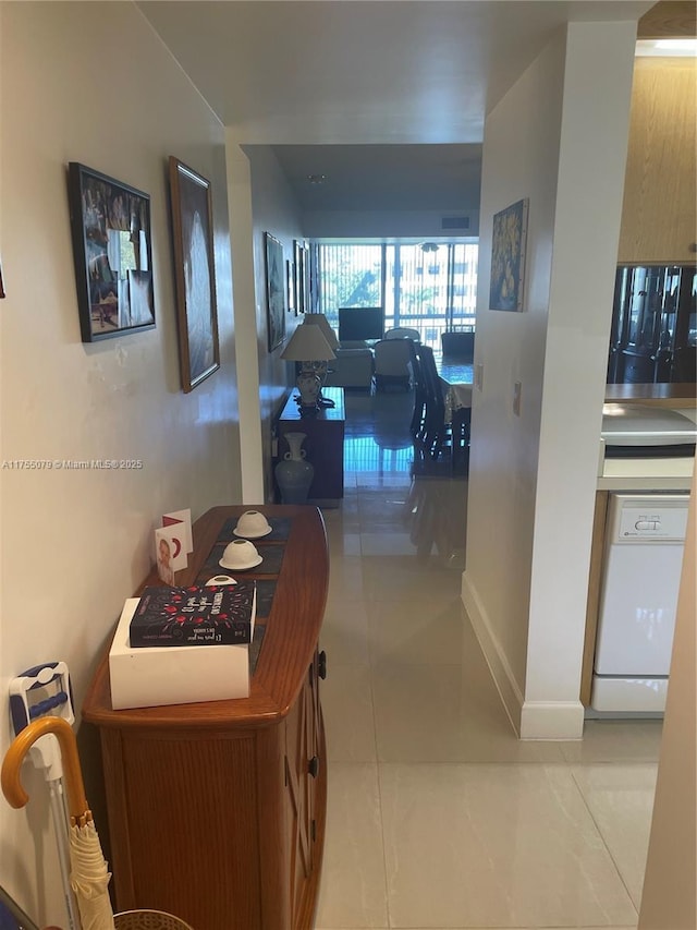 hall featuring tile patterned flooring and baseboards