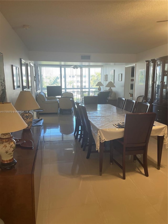 dining space with a healthy amount of sunlight, visible vents, a textured ceiling, and light tile patterned flooring