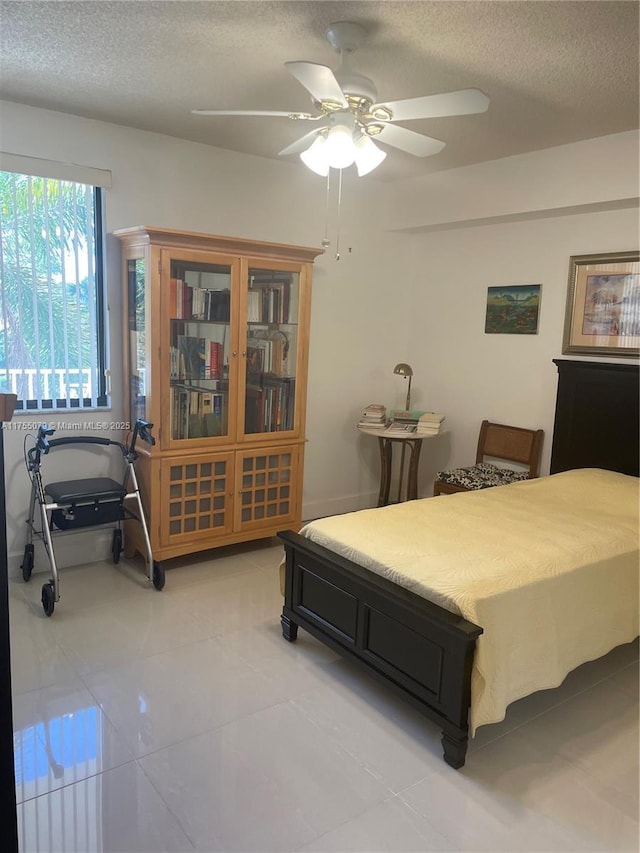 bedroom with a ceiling fan and a textured ceiling